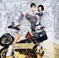 a man and woman posing next to a motorcycle